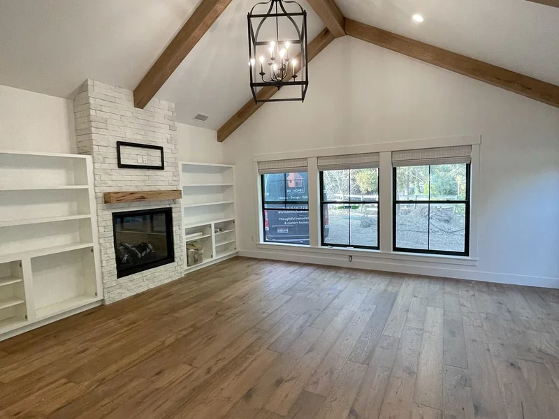 Vaulted ceiling with butternut wood beams over a fireplace and built-ins in a master bedroom addition