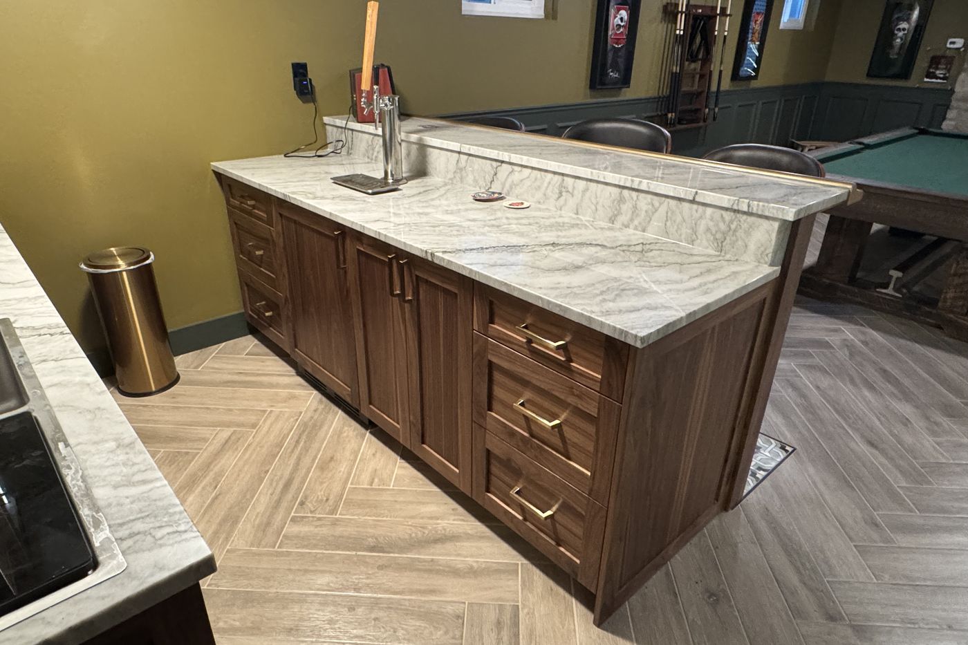 Back side of the basement bar with a raised counter, tap tower, and pool table