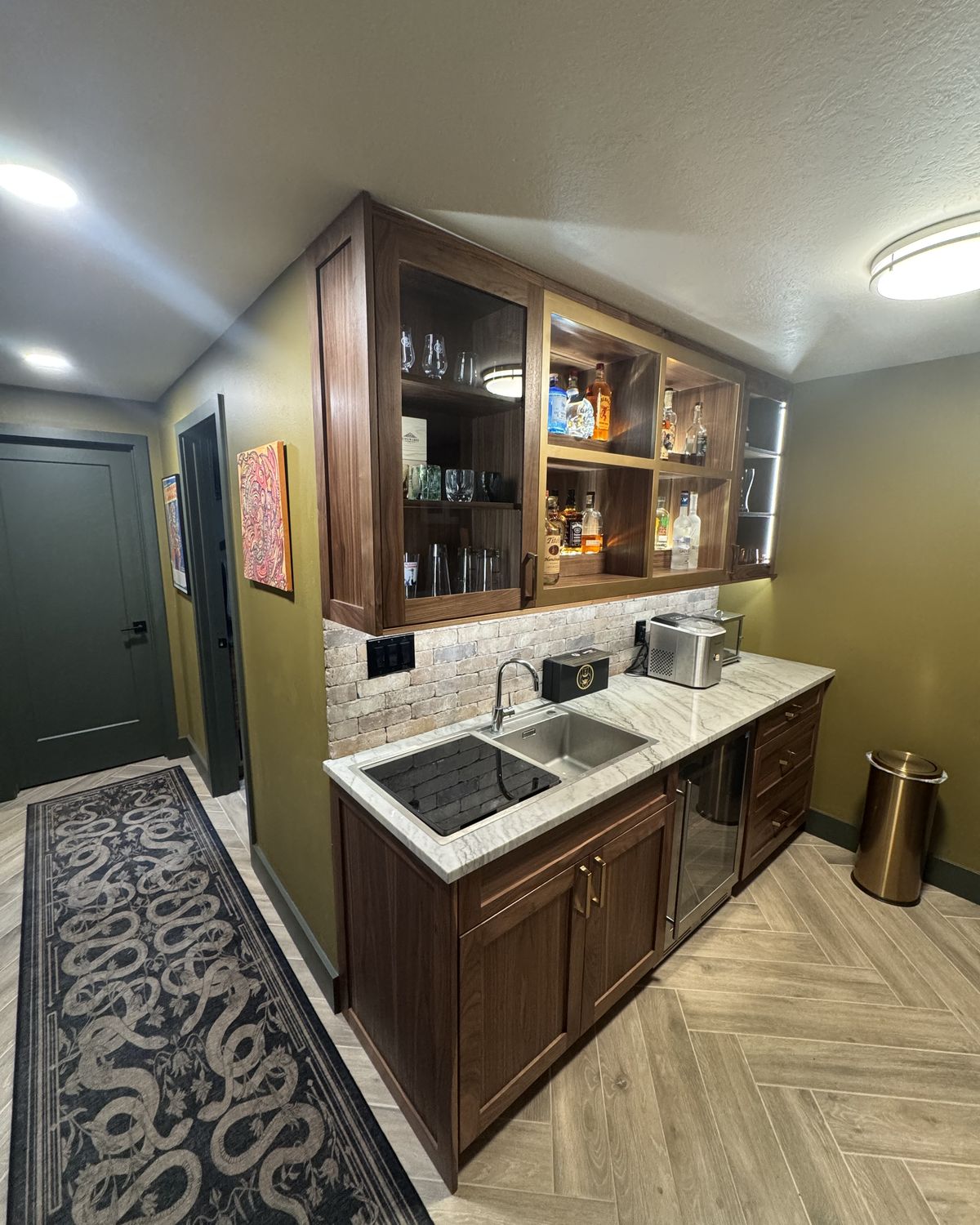 Basement wet bar with walnut cabinets, glass-front uppers, and a quartzite counter