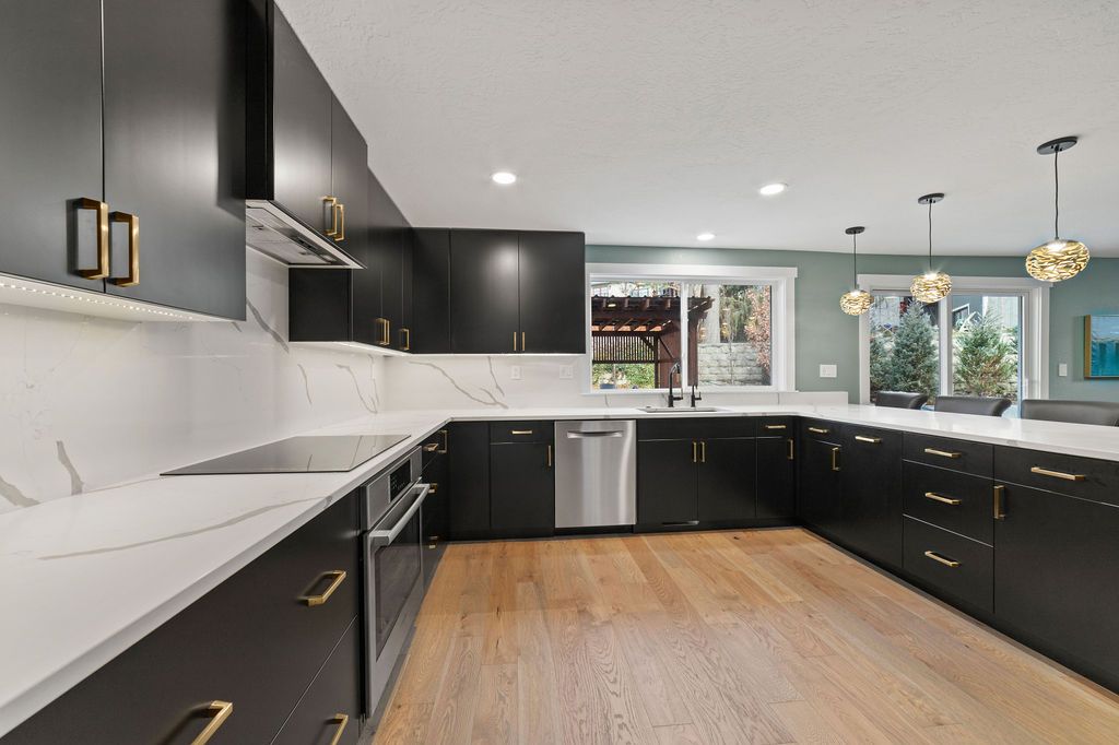 Black cabinet kitchen with a window over the sink